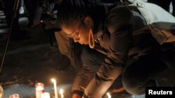 People place candles in a make-shift memorial as they attend a vigil in honor of Bettie Jones, a mother of five and college student Quintonio LeGrier, at Gwendolyn Brooks Academy in Chicago, Illinois, Dec. 29, 2015.