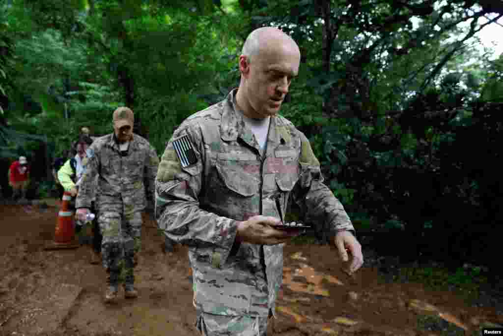 U.S. military personnel come out from Tham Luang cave complex during a search