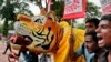 Bangladeshi protesters hold placards and a tiger effigy during a protest demanding the scrapping of the proposed Rampal power plant as they gather near the Shaheed Minar monument in Dhaka, Bangladesh, Saturday, Aug. 20, 2016.