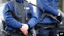 After anti-terrorist raids and a shootout that killed two suspects Thursday, armed Belgian police officers guard a street in Verviers, Belgium, Jan. 16, 2015.