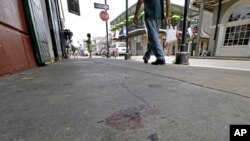 Se ven manchas de sangre en Bourbon Street, donde ocurrió el tiroteo el domingo por la mañana.