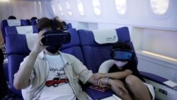 A girl holds her father's hand as she uses a virtual reality (VR) device at a check-in desk at First Airlines, that provides VR flight experiences, including 360-degree tours of cities and meals, amid the COVID-19 pandemic in Tokyo, Japan August 12, 2020.