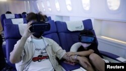 A girl grabs her father's hand while using a virtual reality (VR) device at the First Airlines check-in desk, which offers virtual reality flight experiences, including 360-degree city and meal tours, amidst COVID-19 pandemic in Tokyo, Japan, August 12, 2020.