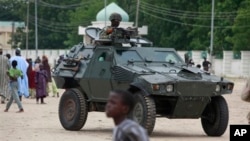 Nigerian soldiers ride on an armored personnel carrier in an area of Nigeria where an Islamic insurgency is raging, in Maiduguri, Nigeria, Aug. 8, 2013.