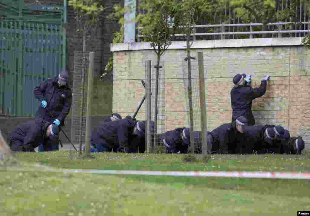 Police officers search near the scene of the killing of a British soldier in Woolwich, London, May 23, 2013. 