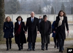 Vice President Mike Pence, center, his wife Karen, second from left, and his daughter Charlotte, left, are lead by Holocaust survivor Abba Naor, as they visit the former Nazi concentration camp in Dachau near Munich, Germany.