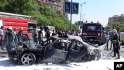 This photo released by the Syrian official news agency SANA, shows Syrian fire fighters extinguishing burning cars after a car bomb exploded in the capital's western neighborhood of Mazzeh, in Damascus, Syria, April 29, 2013.