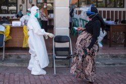 Seorang ibu hamil tiba untuk tes swab COVID-19 di Surabaya, 21 Juli 2020. (Foto: AFP/Juni Kriswanto)