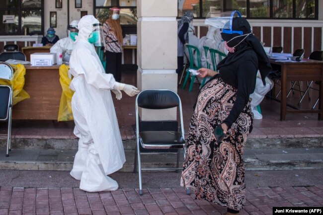 Seorang ibu hamil tiba untuk tes swab virus corona COVID-19 di Surabaya pada 21 Juli 2020. Pemprov Gorontalo sedang menggalakkan program vaksinasi bagi ibu hamil. (Foto: AFP/Juni Kriswanto)