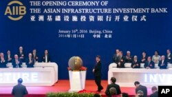 FILE - Representatives of the founding nations of the Asian Infrastructure Investment Bank (AIIB) applaud as Chinese President Xi Jinping, center, unveils a sculpture during the opening ceremony of the AIIB in Beijing, Jan. 16, 2016.