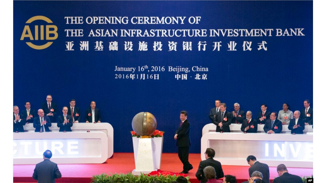FILE - Representatives of the founding nations of the Asian Infrastructure Investment Bank (AIIB) applaud as Chinese President Xi Jinping, center, unveils a sculpture during the opening ceremony of the AIIB in Beijing, Jan. 16, 2016.