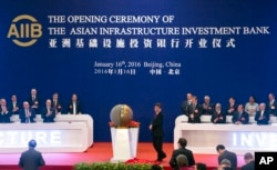 FILE - Representatives of the founding nations of the Asian Infrastructure Investment Bank (AIIB) applaud as Chinese President Xi Jinping, center, unveils a sculpture during the opening ceremony of the AIIB in Beijing, Jan. 16, 2016.