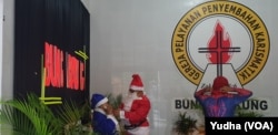 Dua orang muslim berbusana sinterklas dan superhero spiderman berbagi bingkisan Natal untuk anak-anak jemaat Gereja di Solo, Selasa (24/12). Foto : VOA/Yudha Satriawan