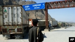 A Pakistani border guard stands near Afghanistan-bound NATO trucks parked on the roadside in Pakistani tribal area of Khyber. (File Photo)