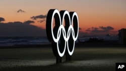 FILE - Olympic rings are placed at the beach before sunrise in Gangneung, South Korea, Jan. 24, 2018. 