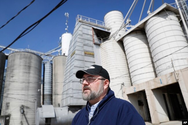 在美国俄亥俄州格林维尔的工厂谷物和大豆筒仓旁边，一位谷物推销员和饲料营养师在讲话（2018年4月5日）。