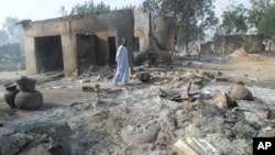 A man walks past burnt out houses following an attack by Boko Haram in Dalori village 5 kilometers (3 miles) from Maiduguri, Nigeria, Jan. 31, 2016.