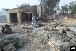 A man walks past burnt-out houses following an attack by Boko Haram in Dalori village 5 kilometers (3 miles) from Maiduguri, Nigeria, Jan. 31, 2016.