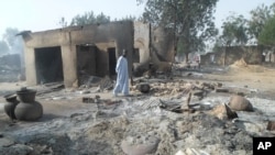 A man walks past burnt out houses following an attack by Boko Haram in Dalori village 5 kilometers (3 miles) from Maiduguri, Nigeria, Jan. 31, 2016.