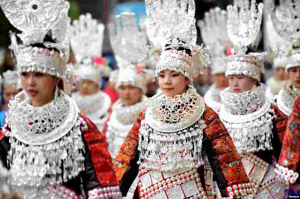 Para perempuan etnis Miao yang mengenakan pakaian tradisional, melakukan parade pada festival di Taijiang, Guizhou, China.