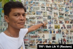 Chairat Ratchapaksi, who founded the Thai and Migrant Fishers Union Group to help trafficked fishermen like him, poses for a photo in front of pictures of rescued trafficking victims in Samut Sakhon, Thailand, March 25, 2018.