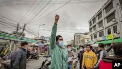 Protesters march through the streets during an anti-government demonstration in Mandalay, Myanmar on Dec. 7, 2021.