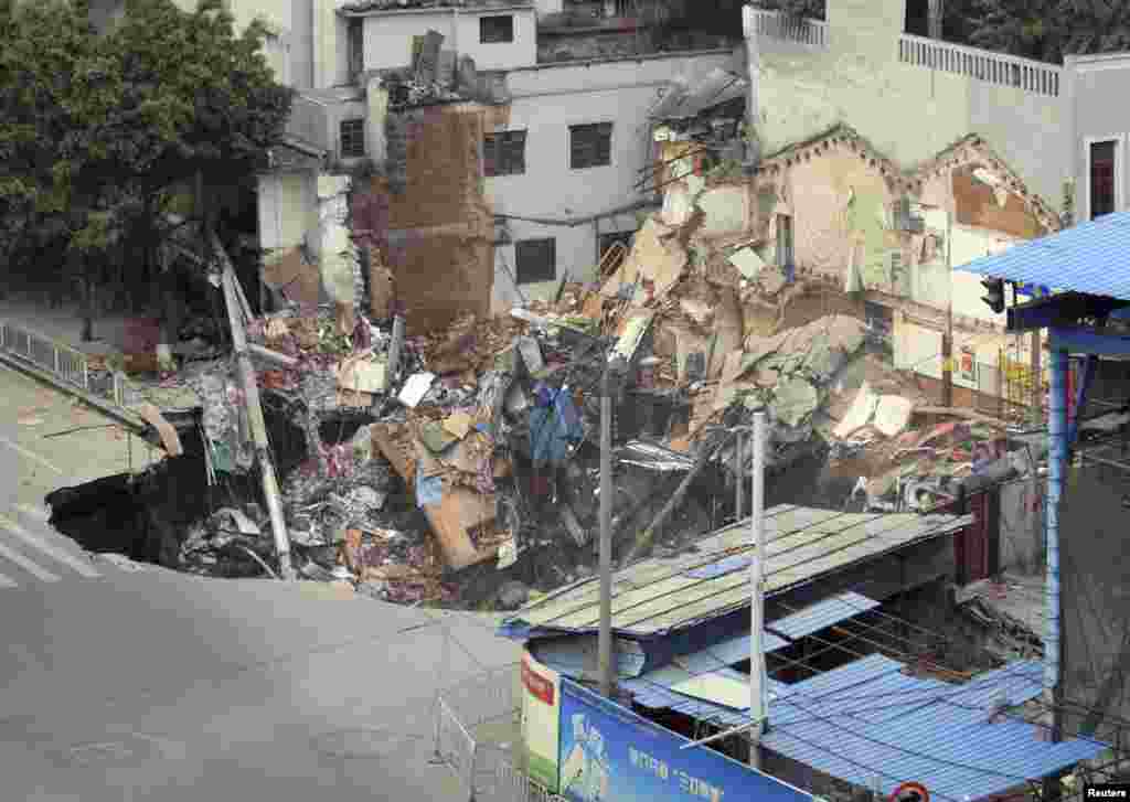 A caved-in area with buildings collapsed inside is seen near the construction site of a new subway line in Guangzhou, Guangdong province, China, January 28, 2013.