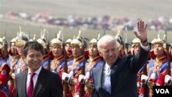 Wapres AS Joe Biden (kanan), didampingi PM Mongolia Batbold Sukhbaatar, melambaikan tangan setibanya di bandara Chinggis Khaan, Mongolia (22/8).