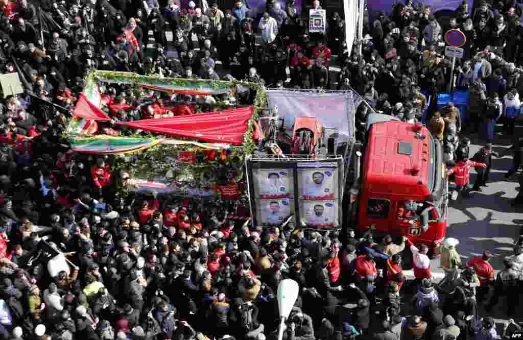 Iranians firefighters and mourners gather around a fire truck carrying the coffins of firemen killed when the city&#39;s oldest high-rise collapsed after a blaze, during the funeral ceremony in the capital Tehran.