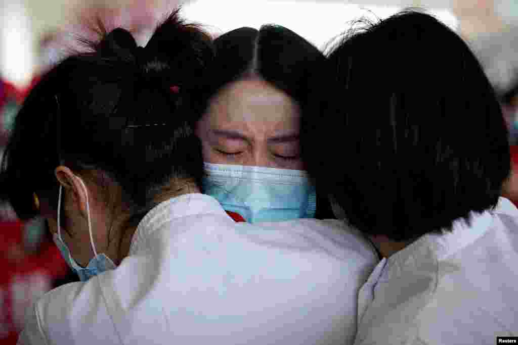 Medical workers hug at the Wuhan Tianhe International Airport after travel restrictions to leave Wuhan, the capital of Hubei province and China&#39;s epicentre of the novel coronavirus disease (COVID-19) outbreak, were lifted.