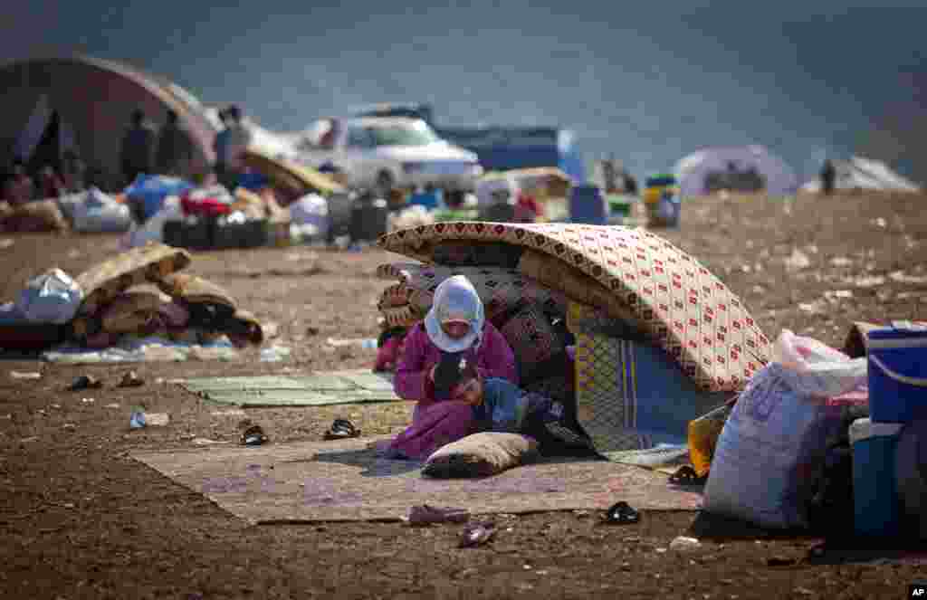 2012年11月7日，一户逃离叙利亚暴力的人家坐在叙利亚边境村庄阿特玛的一处难民营内，身边放着他们携带的家当。这里靠近土耳其边境。