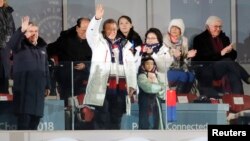 El presidente de Corea del Sur, Moon Jae-in, saluda desde el palco presidencial, junto a su esposa Kim Jung-Sook. Detrás de Moon está Kim Yo-Jong, la hermana del líder norcoreano, Kim Jong-un.