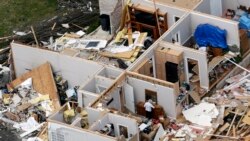 Una mujer recupera un objeto de una casa destrozada, el martes 3 de marzo de 2020, cerca de Lebanon, Tennessee, luego del paso de unos tornados. (AP Foto/Mark Humphrey)