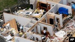 Una mujer recupera un objeto de una casa destrozada, el martes 3 de marzo de 2020, cerca de Lebanon, Tennessee, luego del paso de unos tornados. (AP Foto/Mark Humphrey)