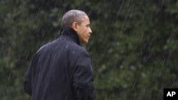 After canceling his appearance at a morning campaign rally in Orlando, Fla., President Barack Obama walks into the White House in a driving rain after returning to Washington to monitor preparations for early response to Hurricane Sandy, Oct. 29, 2012. 