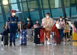 Pengunjung berjalan kaki setelah tiba di Bandara Soekarno-Hatta menyusul keputusan pemerintah Indonesia yang melarang turis asing masuk untuk mencegah penyebaran COVID-19, di Tangerang. (Foto: Reuters)