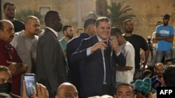 Libya's interim Prime Minister Abdulhamid Dbeibah greets a crowd in Tripoli's Martyrs' Square on Sept. 21, 2021 after the parliament passed a no-confidence vote in the war-scarred country's unity government.