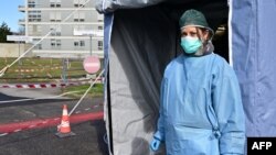 یک پرستار در لباس محافظ، جلوی چادر خدمات پزشکی در مقابل بیمارستان کرمونا در شمال ایتالیا - ۴ مارس ۲۰۲۰ 