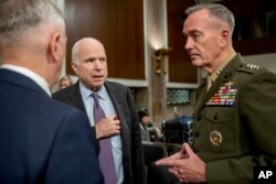 Defense Secretary Jim Mattis, left, and Joint Chiefs Chairman Gen. Joseph Dunford, right, speak with Chairman Sen. John McCain, R-Ariz., second from left, as they arrive to testify on Afghanistan before the Senate Armed Services Committee on Capitol Hill, Washington, Oct. 3, 2017.