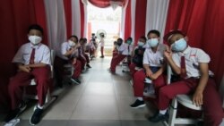 Siswa SD Negeri Cempaka Putih Timur 03 mengantri menunggu antrian untuk di vaksin. Gubernur Jakarta, Anies Baswedan menargetkan sebanyak 1.1 juta anak usia 6 sampai 11 tahun mendapatkan vaksin untuk mencegah tertular virus corona. (VOA/Indra Yoga)