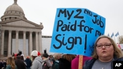 Melissa Knight, who teaches art at Ardmore, Okla. middle school, holds a sign as teachers rally at the state Capitol in Oklahoma City, Monday, April 2, 2018 to protest low school funding. (AP Photo/Sue Ogrocki)