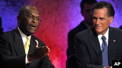 Republican presidential candidate and businessman Herman Cain speaks as former Massachusetts Governor Mitt Romney listens during a Republican presidential debate at Dartmouth College in Hanover, New Hampshire, October 11, 2011.