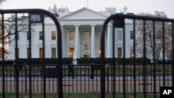 In this March 24, 2019 photo, The White House is seen behind security barriers in Washington.