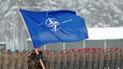 Un soldado alemán enarbola la bandera de la OTAN durante una visita de la entonces ministra de Defensa Ursula von der Leyen a la base de Rukia, Lituania, en 2019.