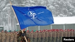 Солдат с флагом НАТО на военной базе в Литве. Архивное фото.