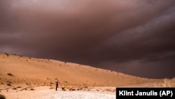 In this undated photo provided by the Palaeodeserts Project in September 2021, a storm arrives during an archaeological excavation of the remains of an ancient lake in northern Saudi Arabia, where ancient humans lived alongside animals such as hippos. (Klint Janulis/Palaeodeserts Project via AP)