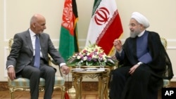 Iranian President Hassan Rouhani, right, talks with his Afghan counterpart Ashraf Ghani at his office in Tehran, Iran, Aug. 5, 2017. 