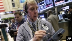 Trader Richard Cohen, right, works on the floor of the New York Stock Exchange, September 7, 2012.