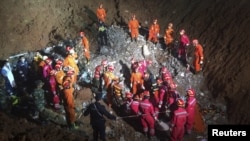 Tim SAR berkerumun di lokasi ditemukannya penyintas, Tian Zeming (19 tahun) di bawah reruntuhan gedung yang robot akibat tanah longsor di Shenzhen, provinsi Guangdong (23/12).