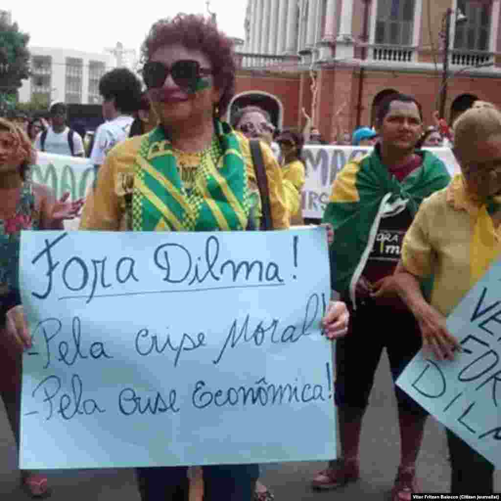 Uma manifestante ergue um cartaz contra a Presidente Dilma Rousseff